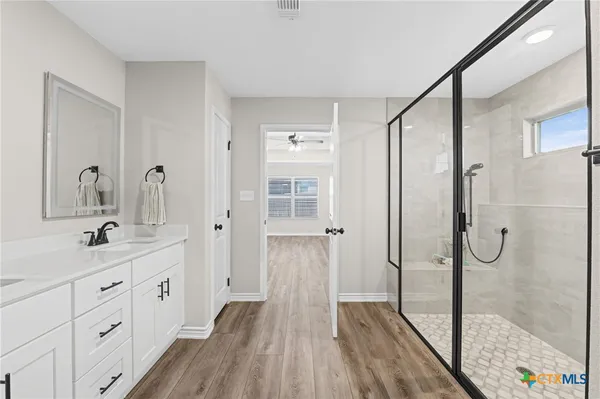 a bathroom with a glass shower door and a mirror