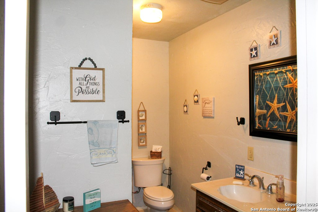 102 Holman Road Lake City, TX 78368 - Photo 11 of 27 a bathroom with a toilet sink and mirror