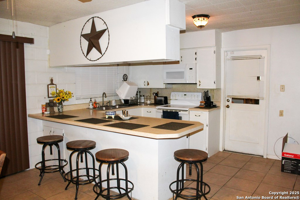 102 Holman Road Lake City, TX 78368 - Photo 15 of 27 a kitchen with stainless steel appliances a sink and a refrigerator