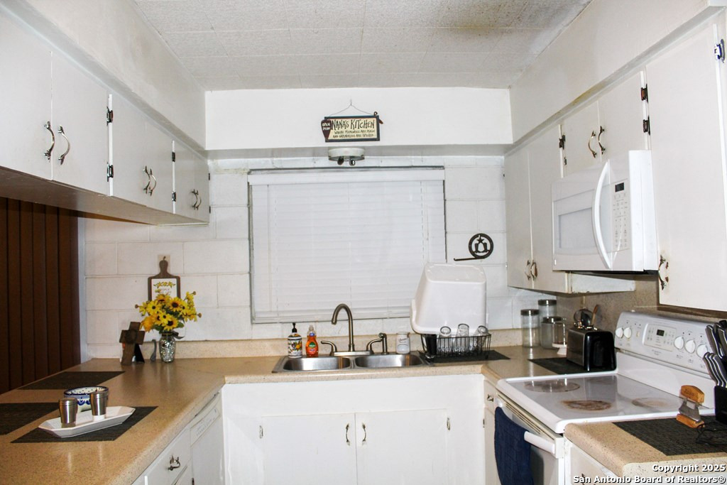 102 Holman Road Lake City, TX 78368 - Photo 16 of 27 a kitchen with cabinets a sink and appliances