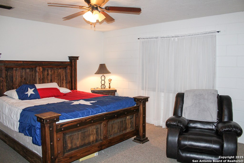 102 Holman Road Lake City, TX 78368 - Photo 8 of 27 a bedroom with a bed and a chandelier
