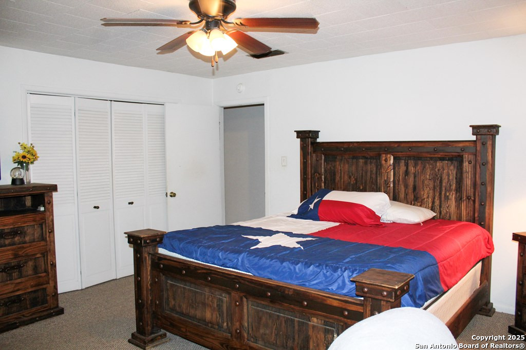 102 Holman Road Lake City, TX 78368 - Photo 9 of 27 a bedroom with a bed and a chandelier