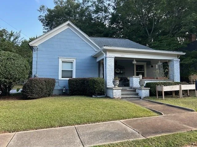a view of a house with a yard and sitting area
