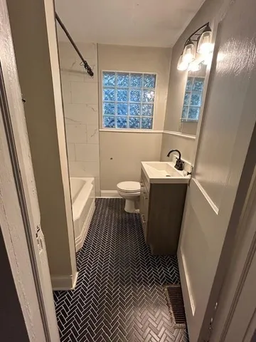 a bathroom with sink and mirror with toilet