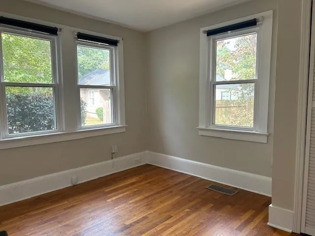 a view of a room with wooden floor and windows in it