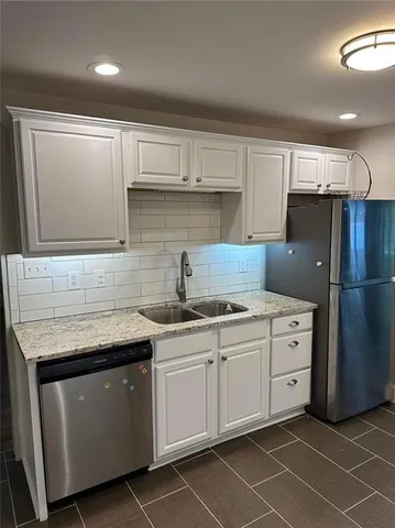 a kitchen with a sink a refrigerator and cabinets