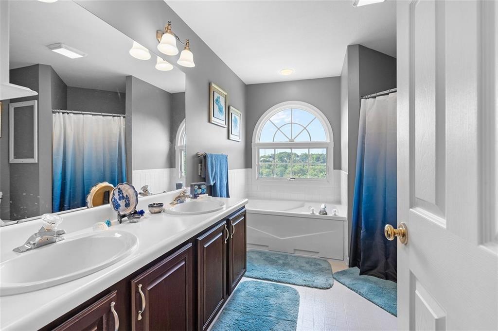 247 Randy Lane Coraopolis, PA 15108 - Photo 24 of 39 a bathroom with a granite countertop bathtub a sink and a large mirror