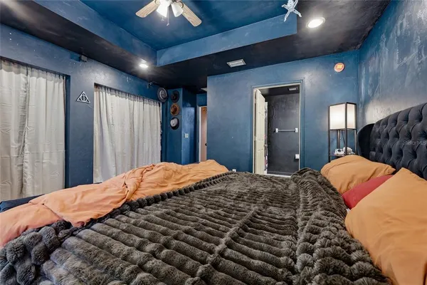 a bed sitting in a bedroom next to a window and a lamp