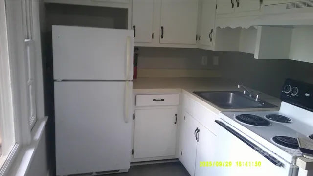 a kitchen with a refrigerator sink and cabinets