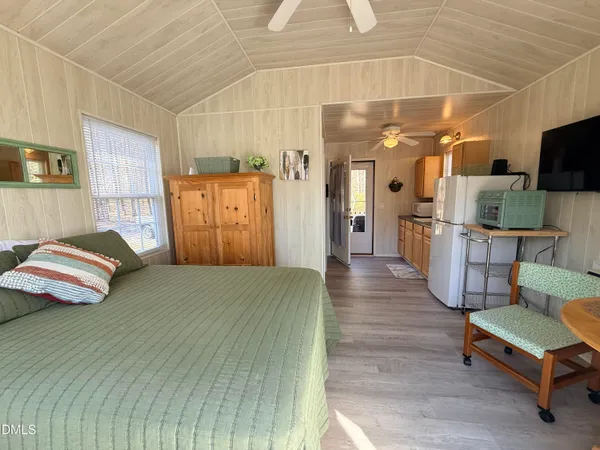 a spacious bedroom with a bed and a view of living room