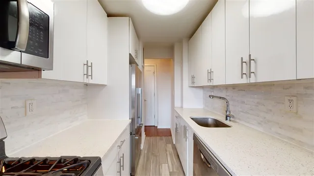a kitchen with a sink and a stove top oven