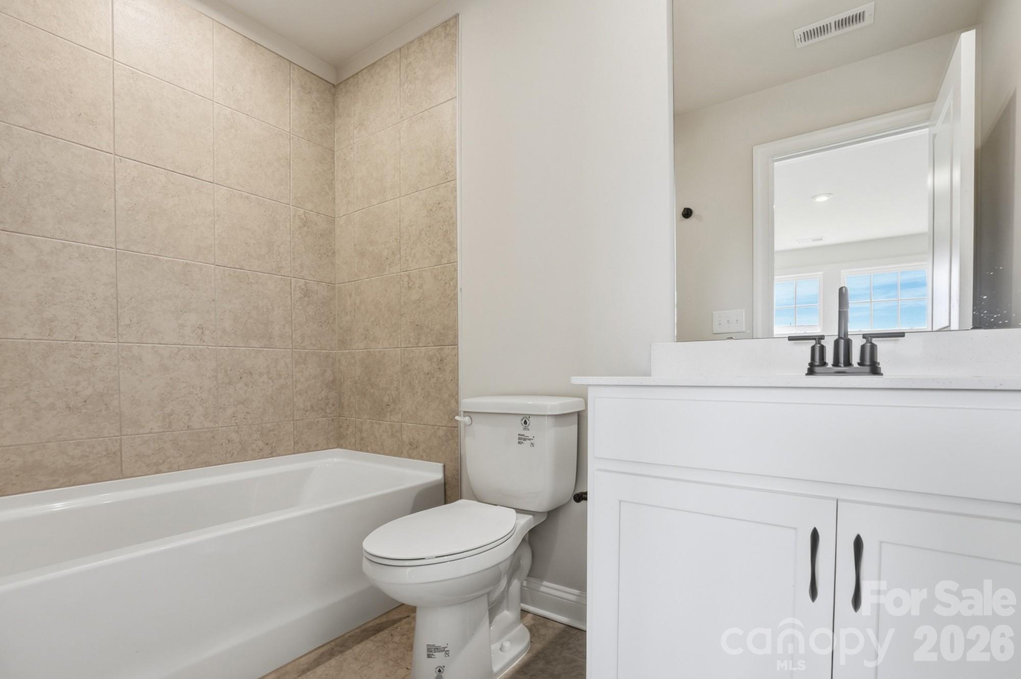 2608 Mabel Lane Monroe, NC 28110 - Photo 25 of 36 a bathroom with a toilet a sink a mirror and bathtub