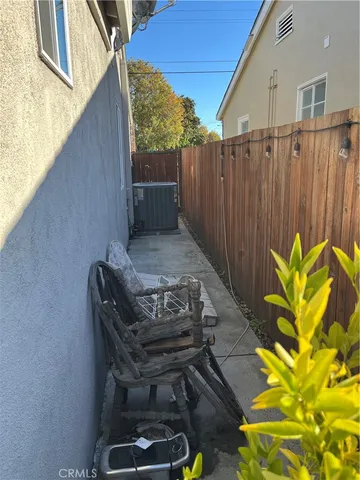 a backyard of a house with table and chairs and wooden fence