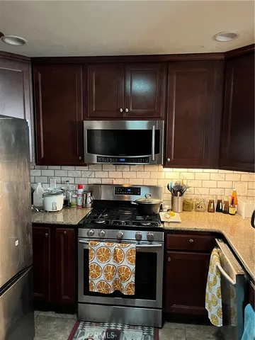 a kitchen with stainless steel appliances wooden cabinets and a stove top oven