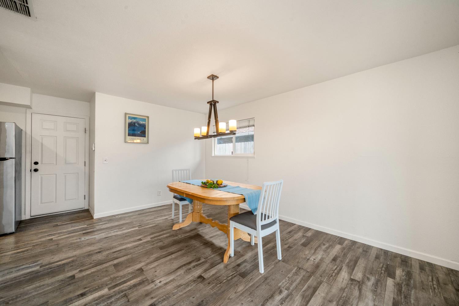 7358 Candlelight Way Citrus Heights, CA 95621 - Photo 16 of 45 a dining room with wooden floor a chandelier a wooden table and chairs