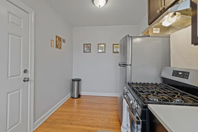 a kitchen with stainless steel appliances granite countertop a refrigerator and a stove top oven