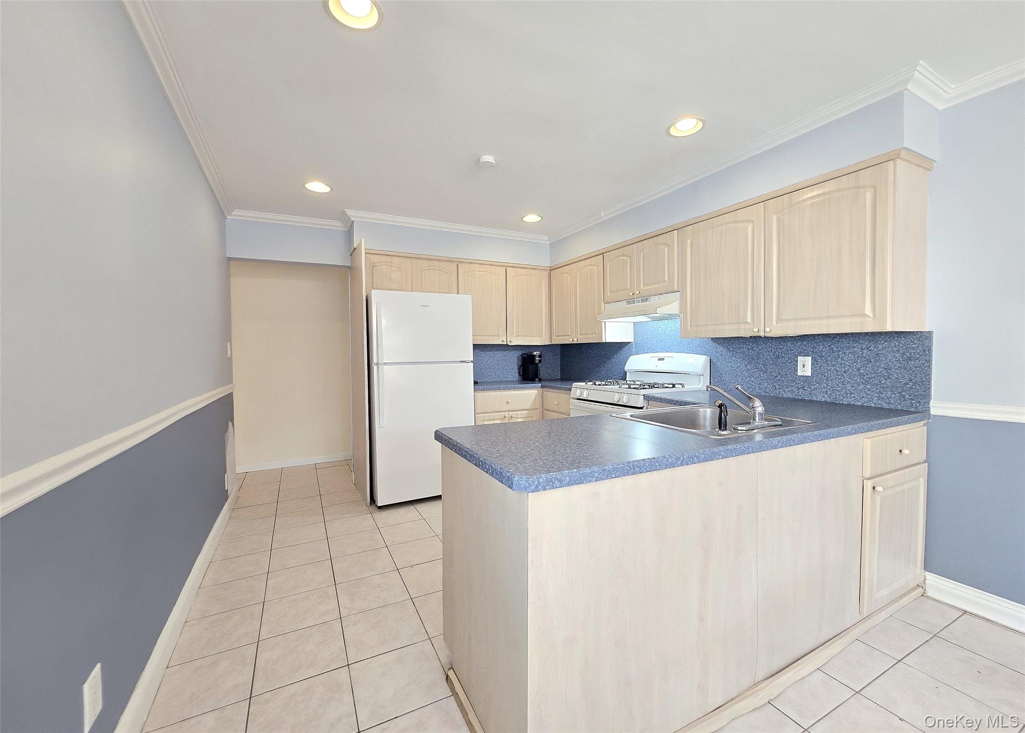 585 Pulaski Road Kings Park, NY 11754 - Photo 13 of 28 a kitchen with stainless steel appliances granite countertop a sink and a refrigerator