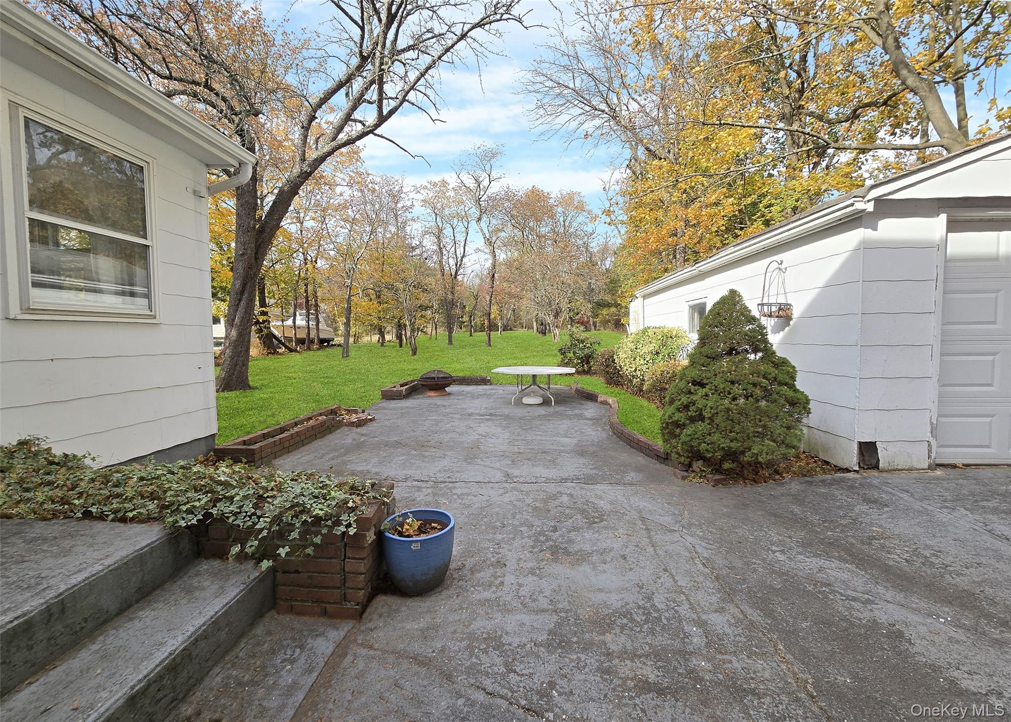585 Pulaski Road Kings Park, NY 11754 - Photo 2 of 28 a view of a backyard with potted plants and large trees