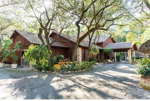 a front view of a house with a yard and a garden