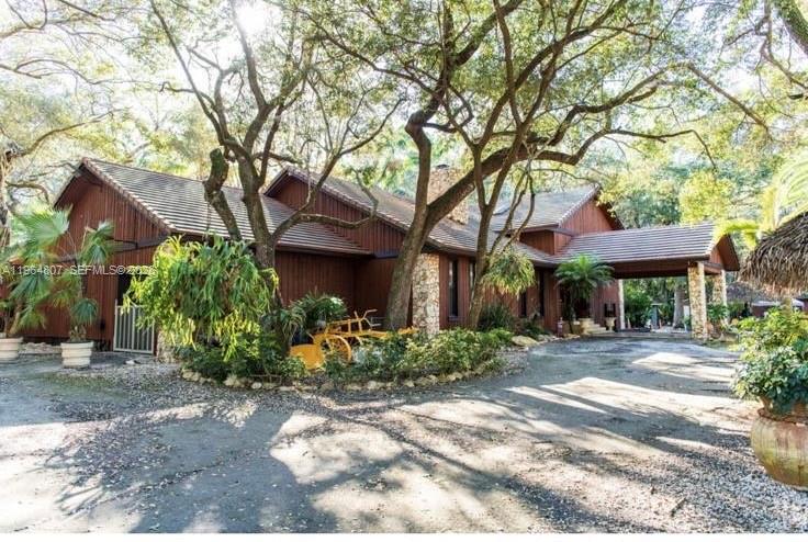 a front view of a house with a yard and a garden