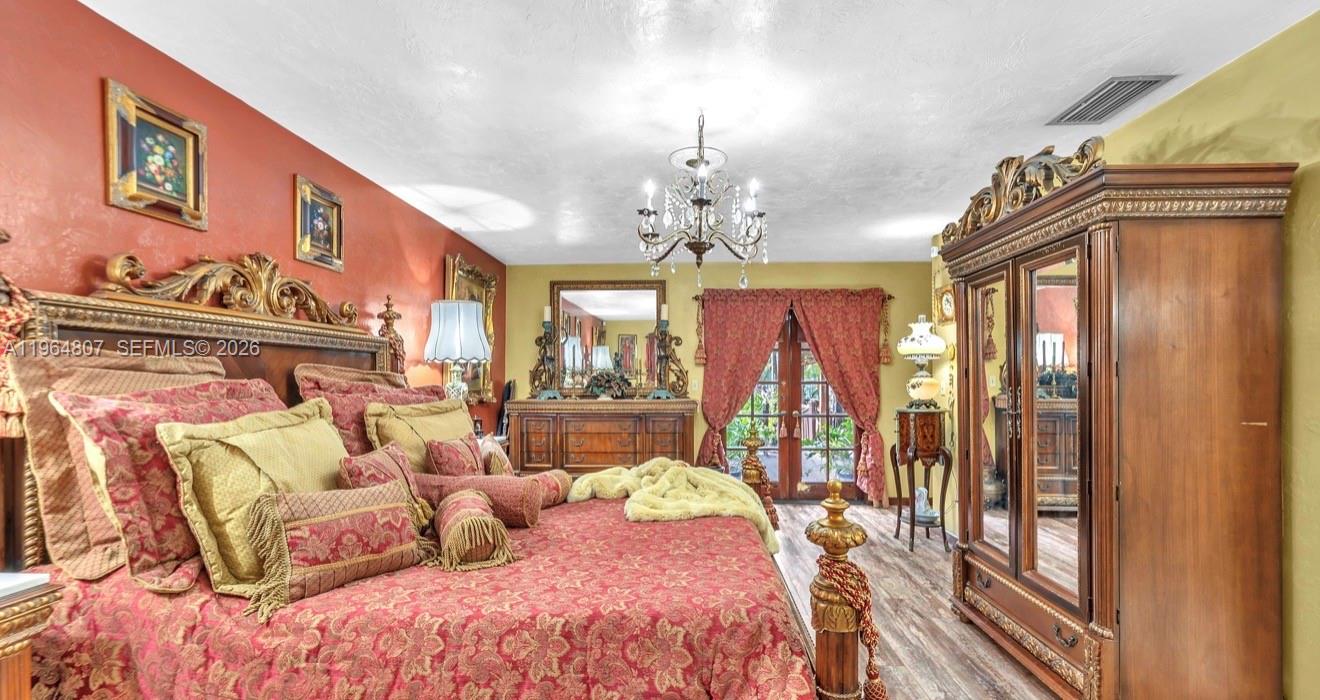 15425 Southwest 268th Street Homestead, FL 33032 - Photo 20 of 62 a bedroom with a bed and a chandelier