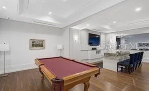 a room with furniture a flat screen tv and kitchen view