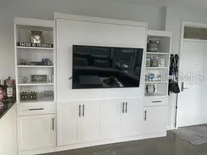 a kitchen with white cabinets and a stove with wooden floor