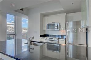 1350 Main Street, Unit 304 Sarasota, FL 34236 - Photo 5 of 14 a kitchen with stainless steel appliances a refrigerator and a stove