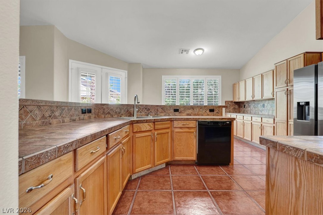 7308 Rustic Meadow Street Las Vegas, NV 89131 - Photo 5 of 27 A well-appointed kitchen showcasing durable tiled flooring and extensive cabinetry for optimal storage.