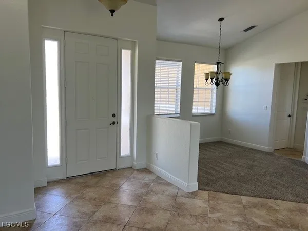 an empty room with windows and cabinet