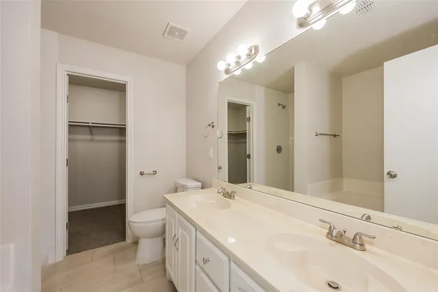 a spacious bathroom with a granite countertop sink a toilet and shower