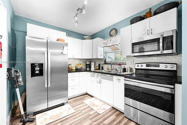 a kitchen with stainless steel appliances granite countertop a refrigerator and a sink