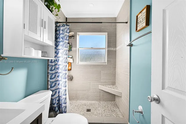 a bathroom with a sink a toilet a mirror and shower