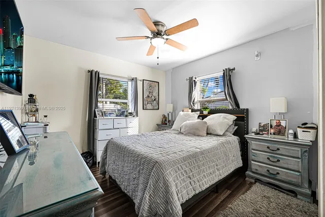 a bedroom with a large bed and a flat tv screen on dresser