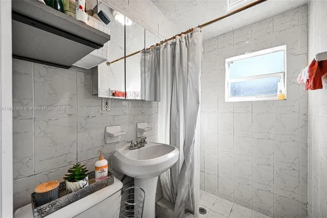 a view of a backyard with table and chairs potted plants and large tree
