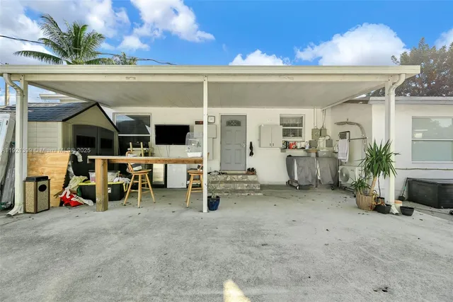 a view of a patio with table and chairs a barbeque with wooden fence