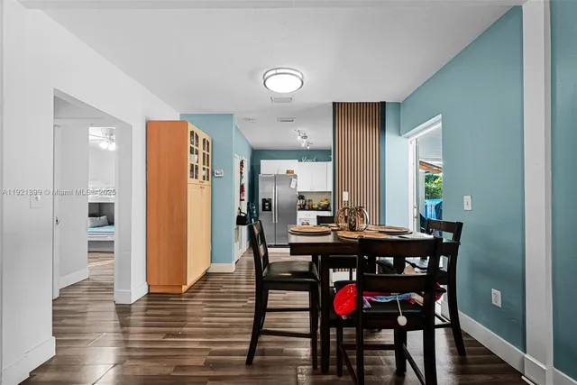 a living room with furniture a table and kitchen view