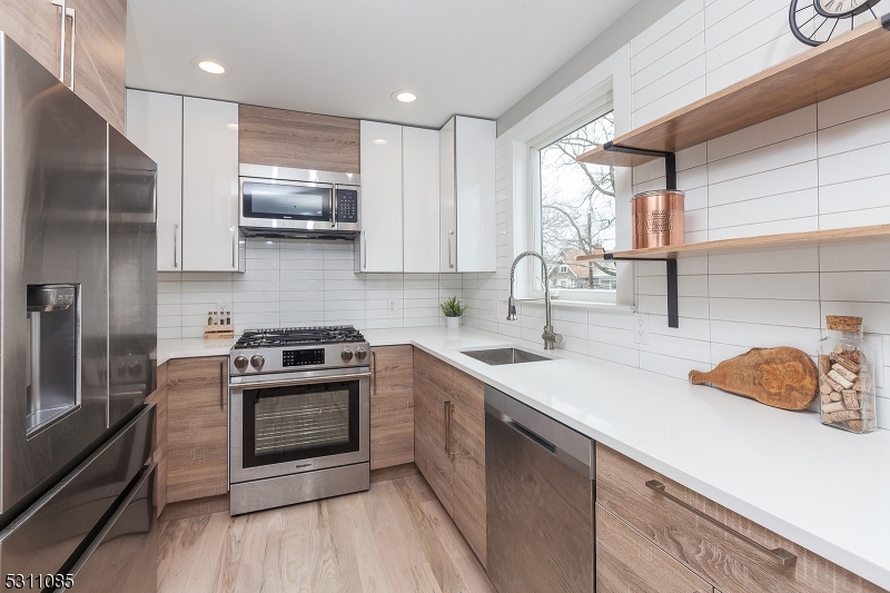 27 Mission Street, Unit 2 Montclair, NJ 07042 - Photo 5 of 18 a kitchen with stainless steel appliances granite countertop a sink stove and refrigerator