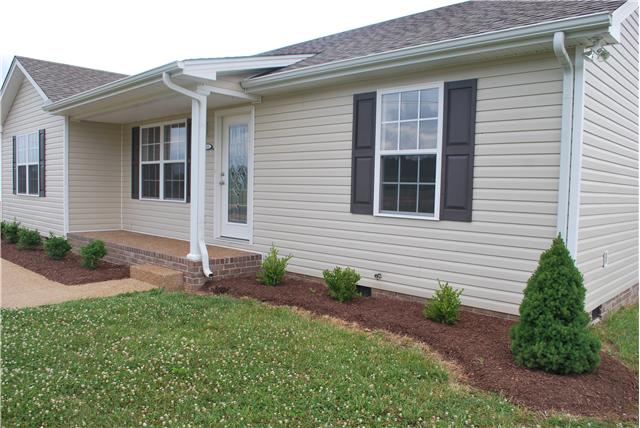 144 T G T Road Portland, TN 37148 - Photo 17 of 20 New landscaping and fresh mulch along a raised aggregate sidewalk welcomes your guest