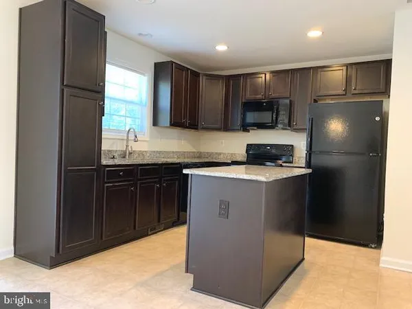 a kitchen with stainless steel appliances granite countertop a refrigerator and a stove top oven