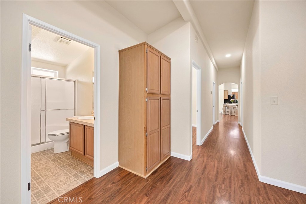 37055 De Portola Road Temecula, CA 92592 - Photo 50 of 67 a view of a hallway with wooden floor and a bathroom