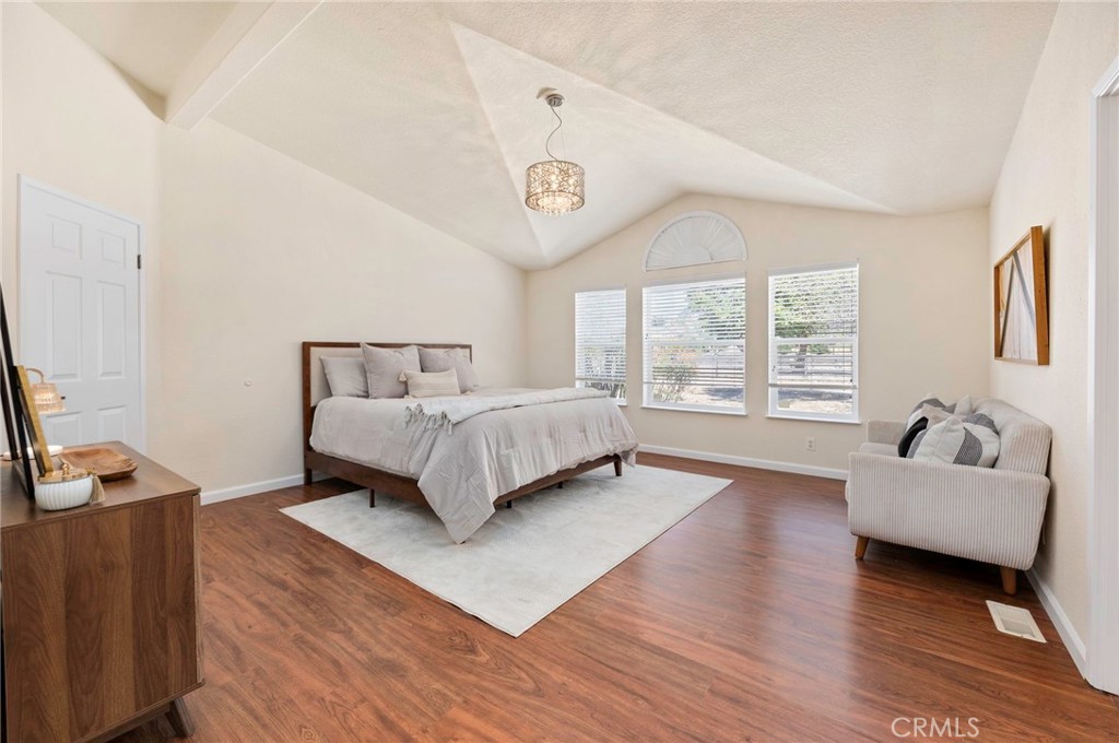 37055 De Portola Road Temecula, CA 92592 - Photo 53 of 67 a spacious bedroom with a bed a couch and a window with wooden floor