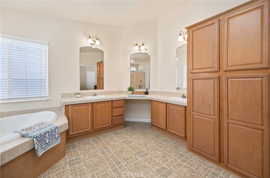 37055 De Portola Road Temecula, CA 92592 - Photo 58 of 67 a large bathroom with a double vanity sink a mirror and a bathtub