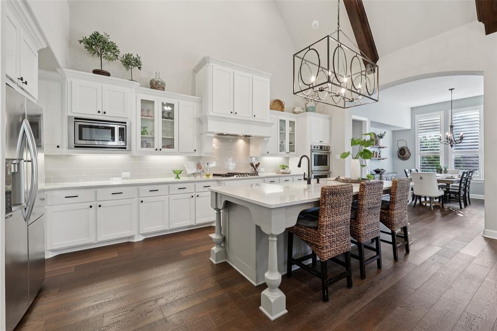 451 Morgan Lane Prosper, TX 75078 - Photo 12 of 38 a kitchen with cabinets a sink dishwasher a dining table and chairs with wooden floor
