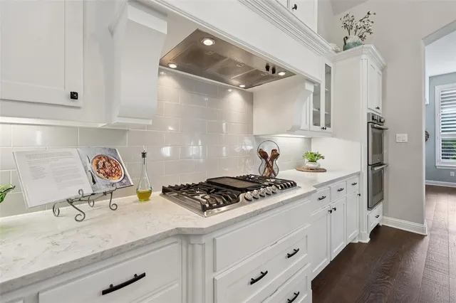 a kitchen with stainless steel appliances granite countertop a sink stove and cabinets
