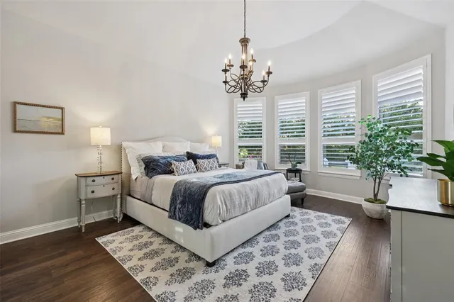 a bedroom with a large bed and a chandelier