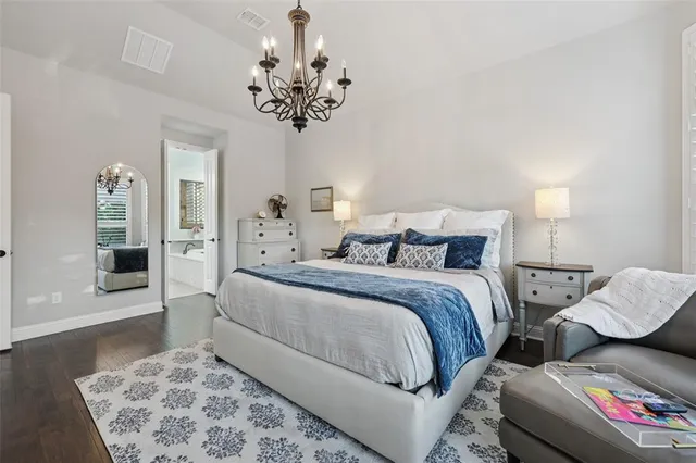 a bedroom with a bed and a chandelier