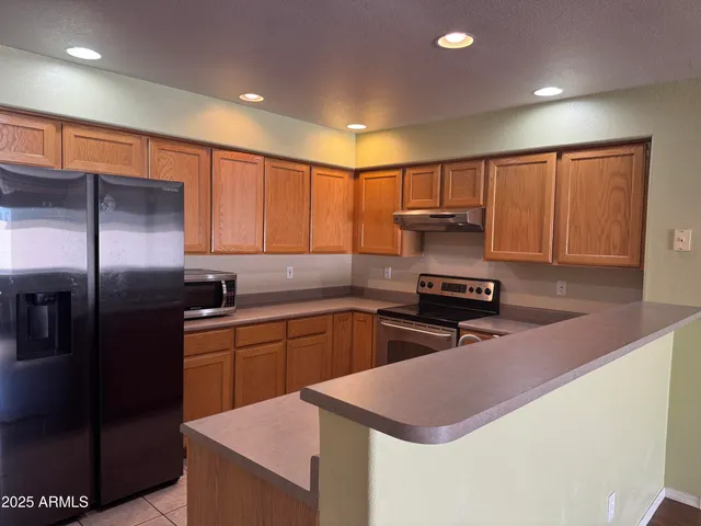 a kitchen with kitchen island granite countertop a sink stainless steel appliances and cabinets