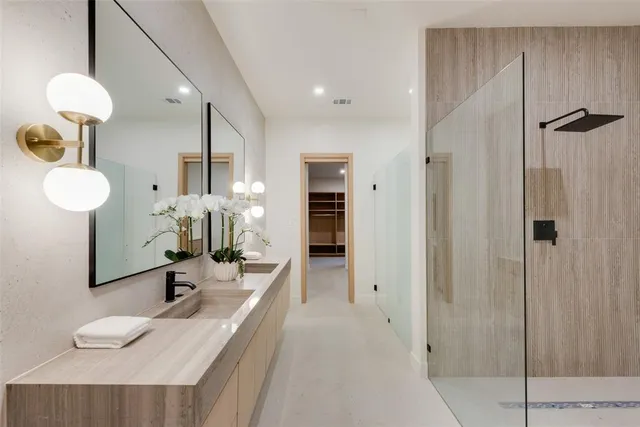 a bathroom with a double vanity sink mirror and shower