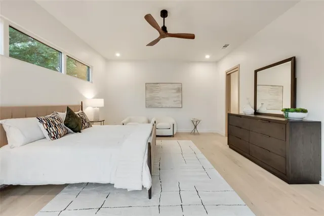 a bedroom with a large bed and a chandelier